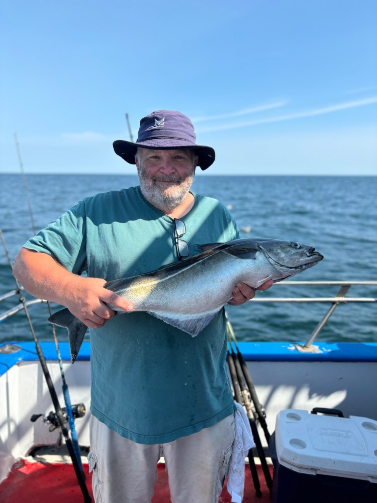 a man holding a fish in the water