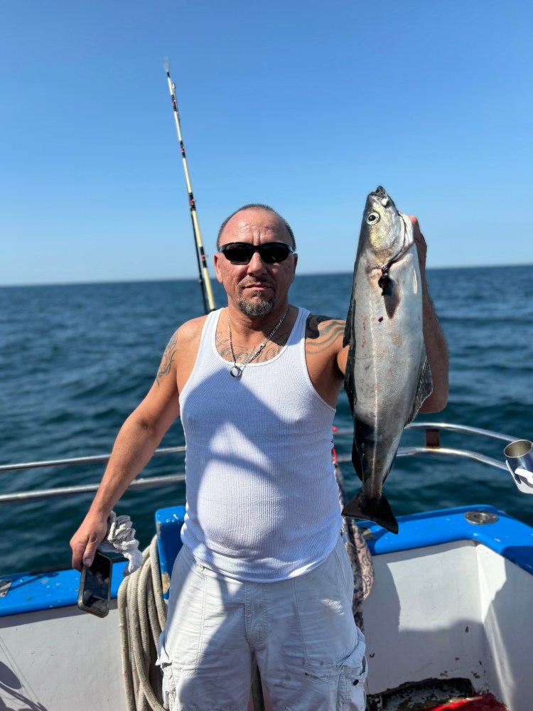 a man holding a fish in the water