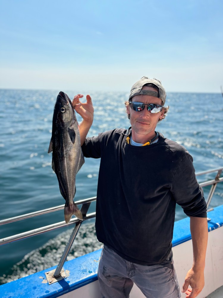 a man holding a fish in the water