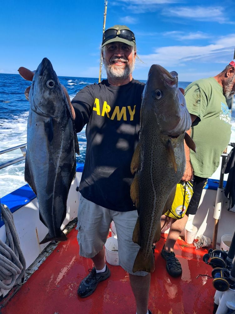 a group of people standing next to a person holding a fish