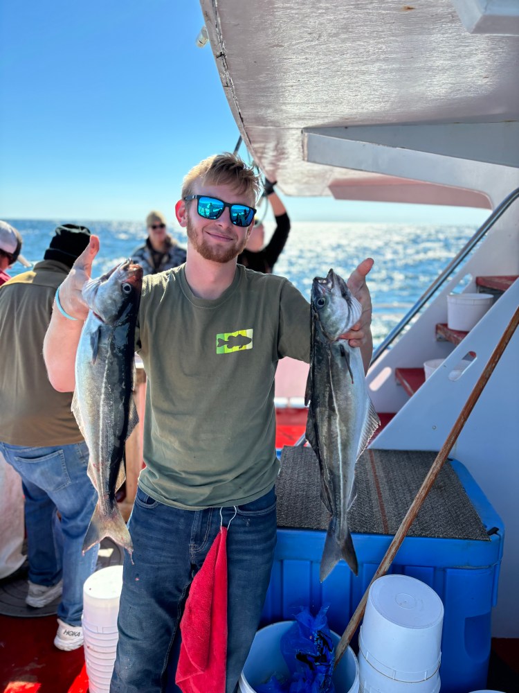 a man holding a fish on a boat