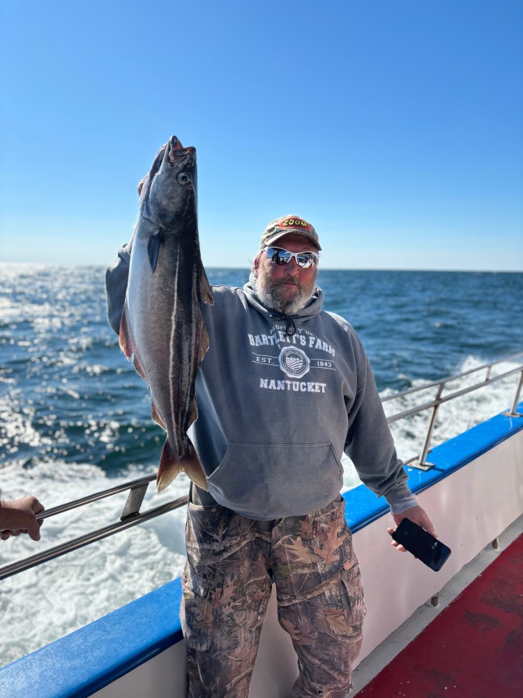 a man holding a fish in the water