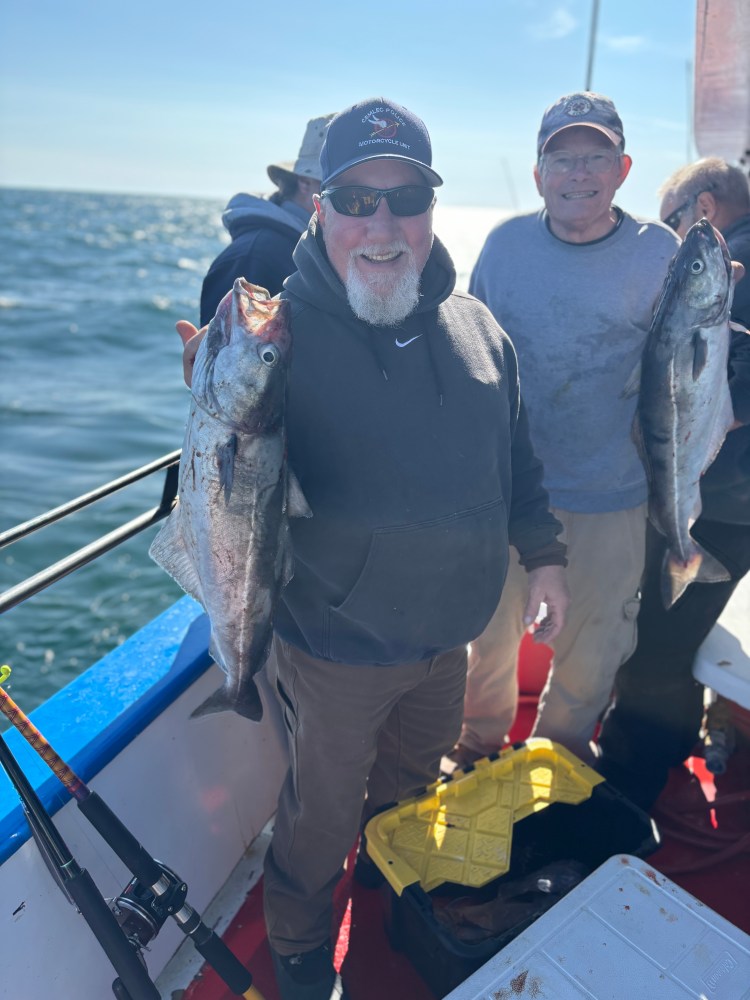 a group of people standing next to a person holding a fish