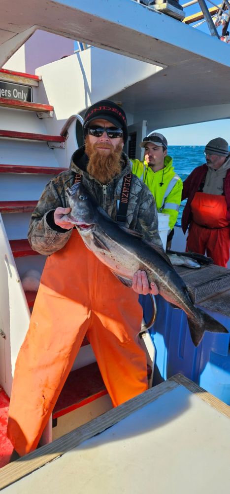 a man holding a fish on a boat