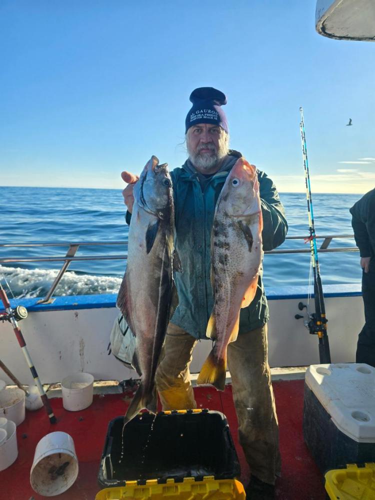 a man holding a fish on a boat