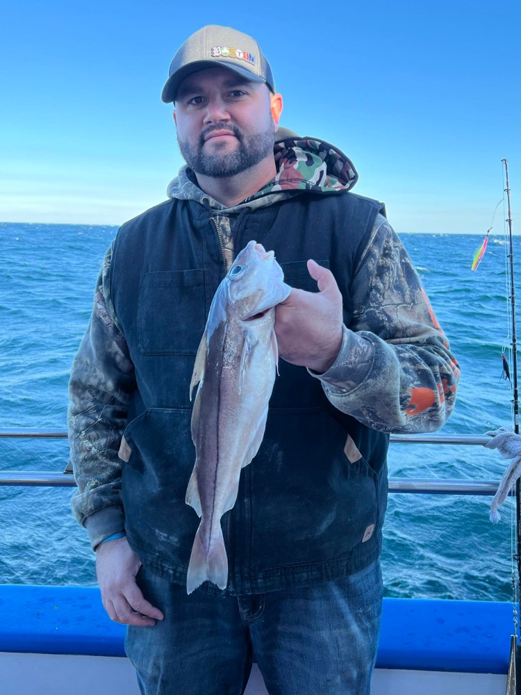 a man holding a fish in a body of water