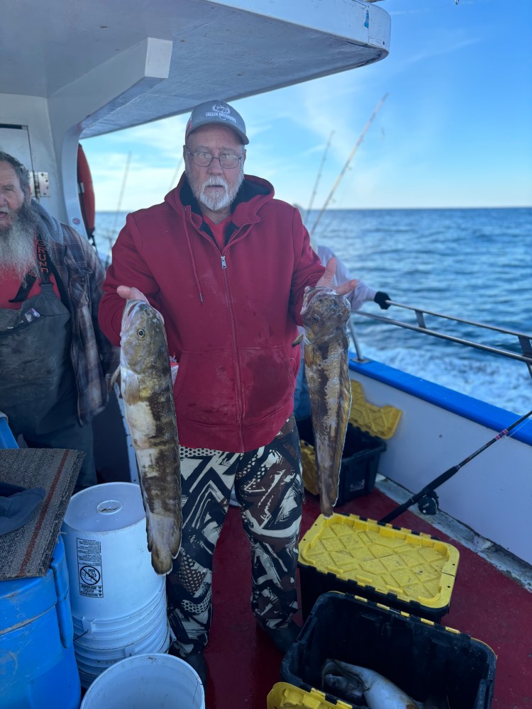 a man holding a fish on a boat