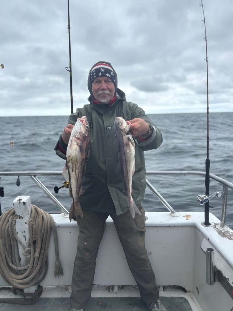 a man holding a fish on a boat