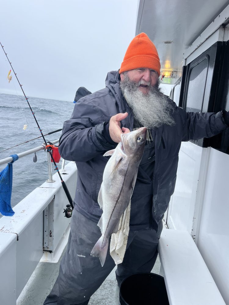 a person holding a fish on a boat
