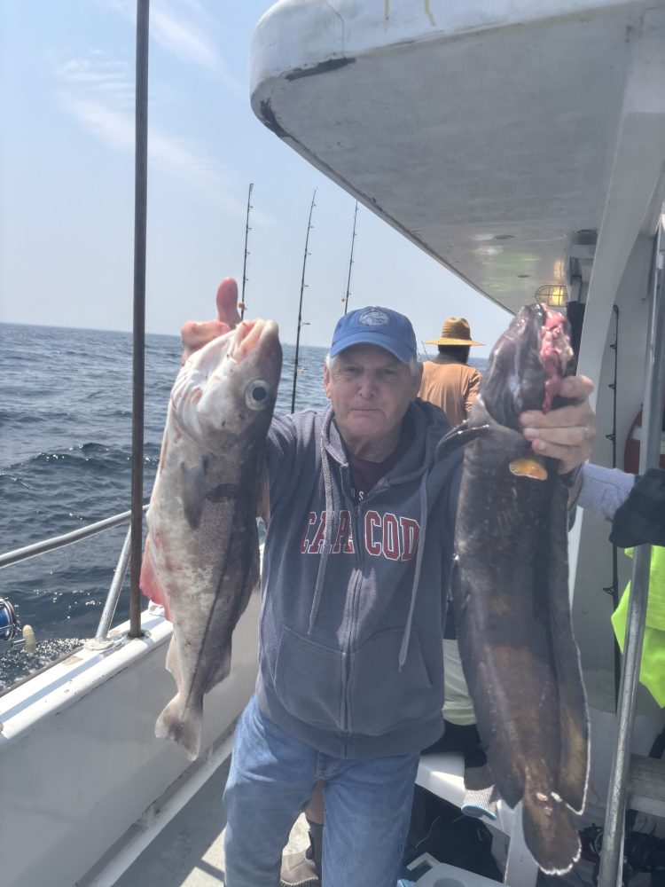 a man holding a fish on a boat