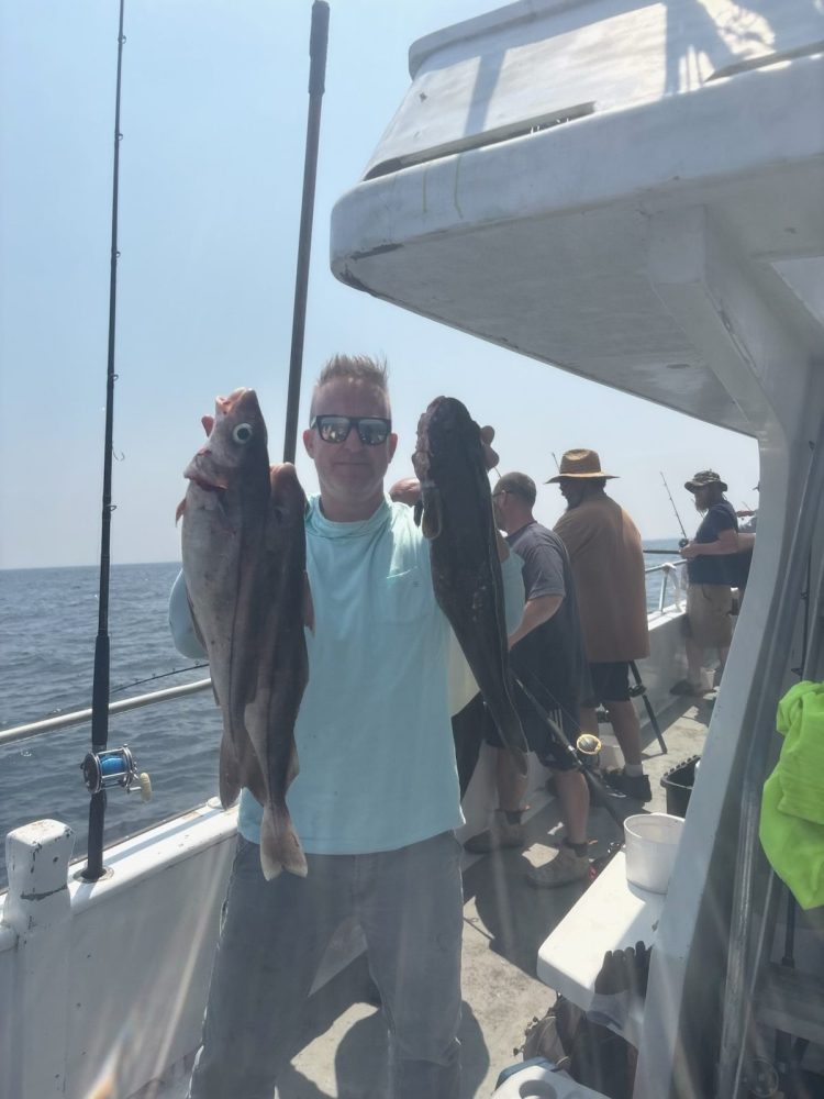 a group of people standing next to a fish on a boat