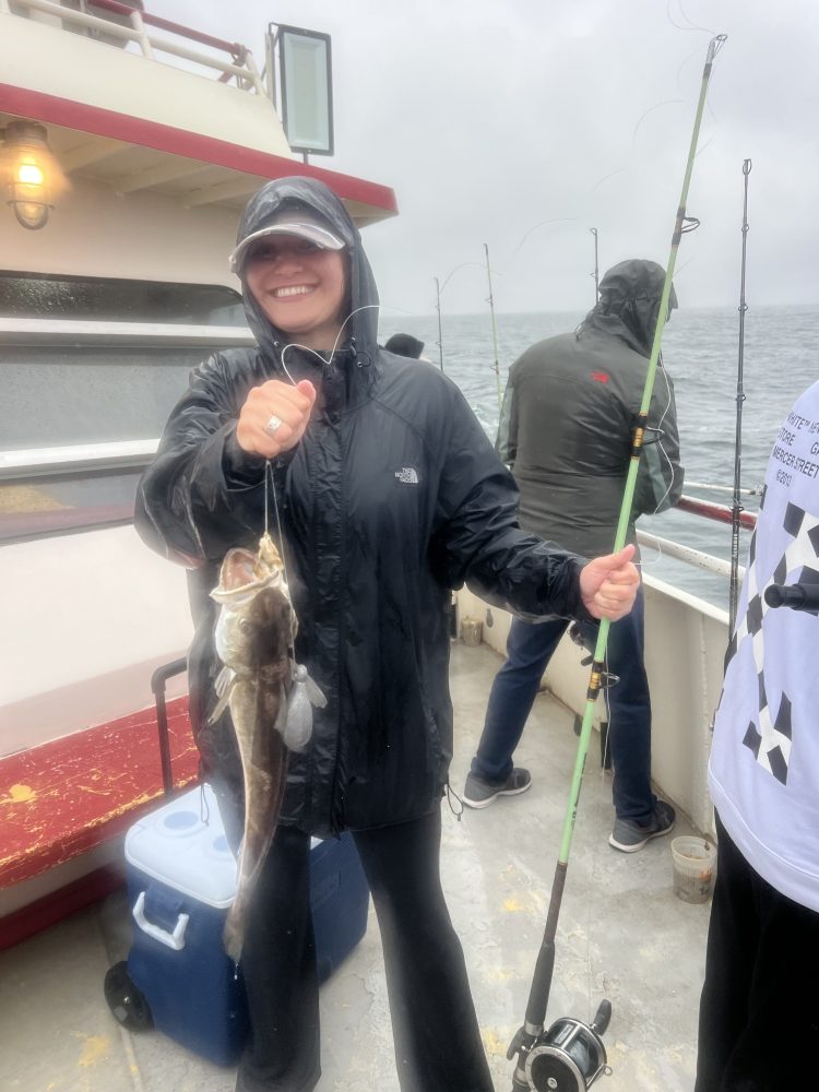 a person holding a fish on a boat