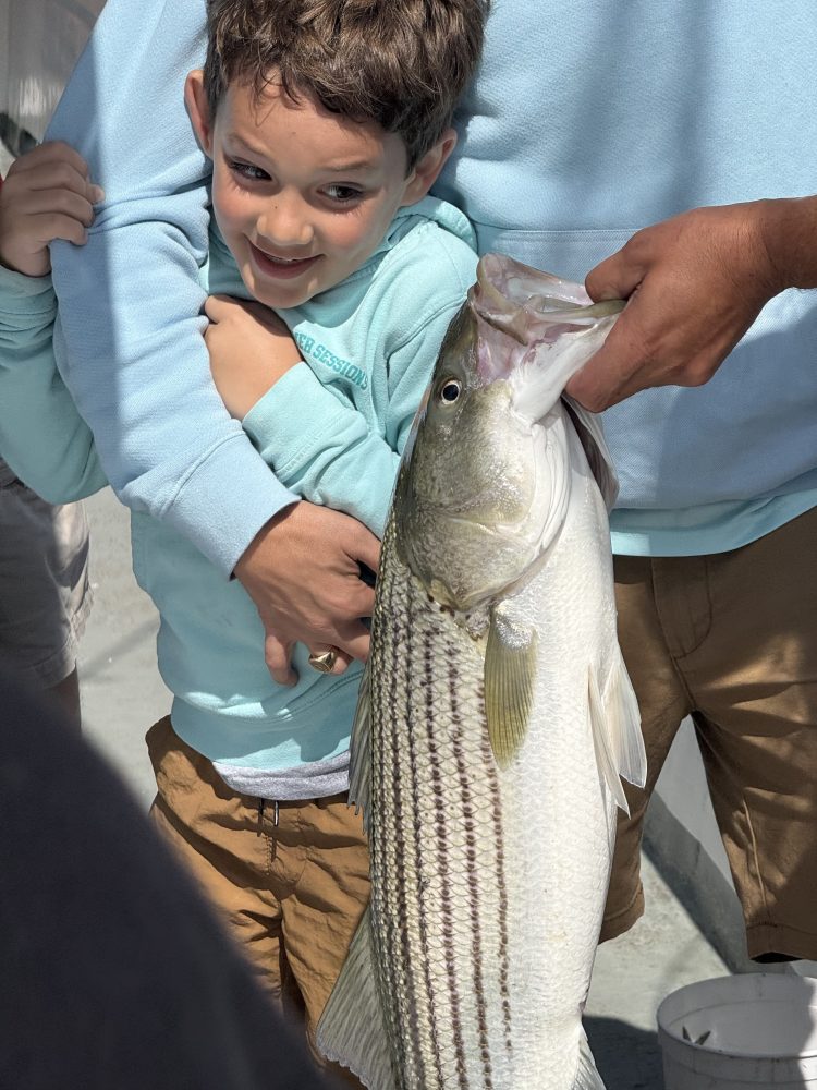a young boy holding a fish