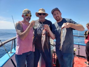 a group of people standing next to a person holding a fish