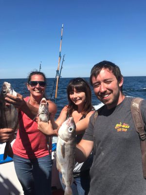 a person holding a fish posing for the camera