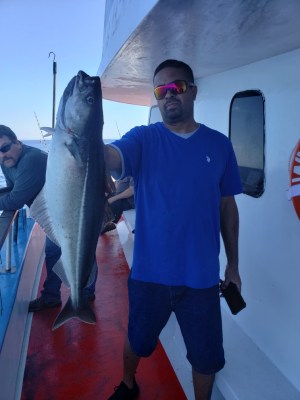a man holding a fish posing for the camera