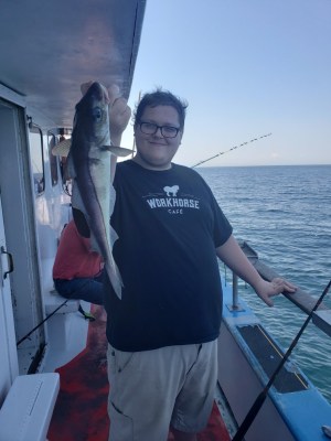 a man holding a fish on a boat