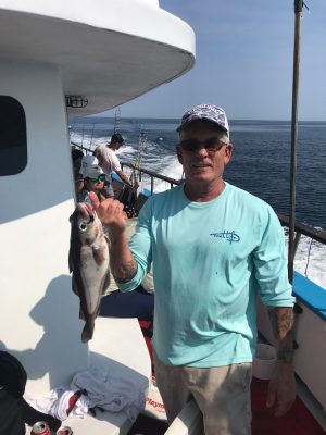 a man holding a fish in the water