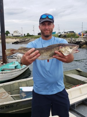 a man holding a fish on a boat