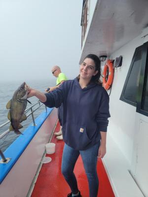 a person holding a fish on a boat