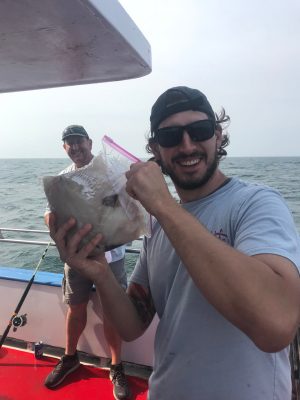 a man standing next to a body of water