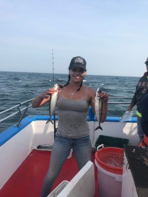 a couple of people standing next to a body of water
