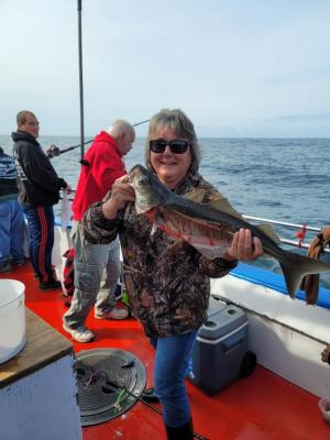 a person holding a fish on a boat