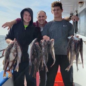 a group of people standing next to a person holding a fish