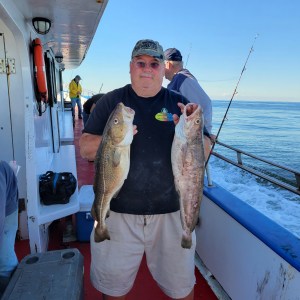 a man holding a fish on a boat
