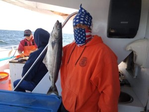 a man holding a fish on a boat