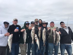 a group of people standing in front of a fish