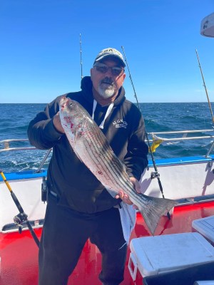 a person holding a fish on a boat in the water