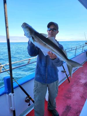 a person holding a fish on a boat in a body of water