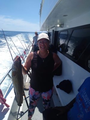 a person holding a fish posing for the camera