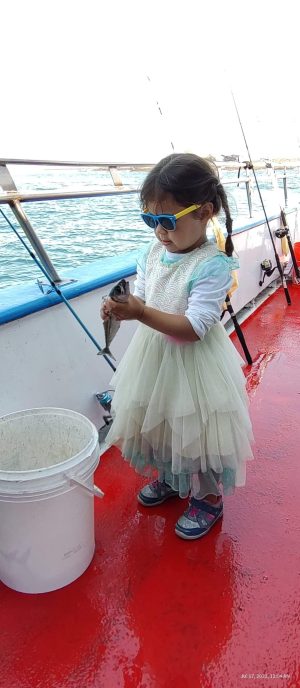 a little girl standing in front of water