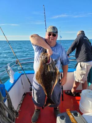 a person holding a fish on a boat in the water