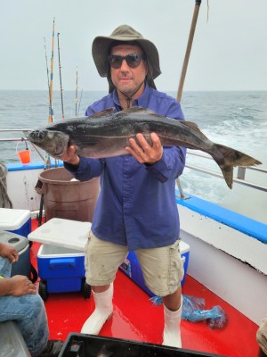 a man holding a fish on a boat