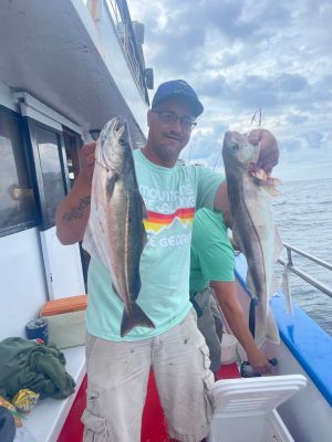 a man holding a fish on a boat